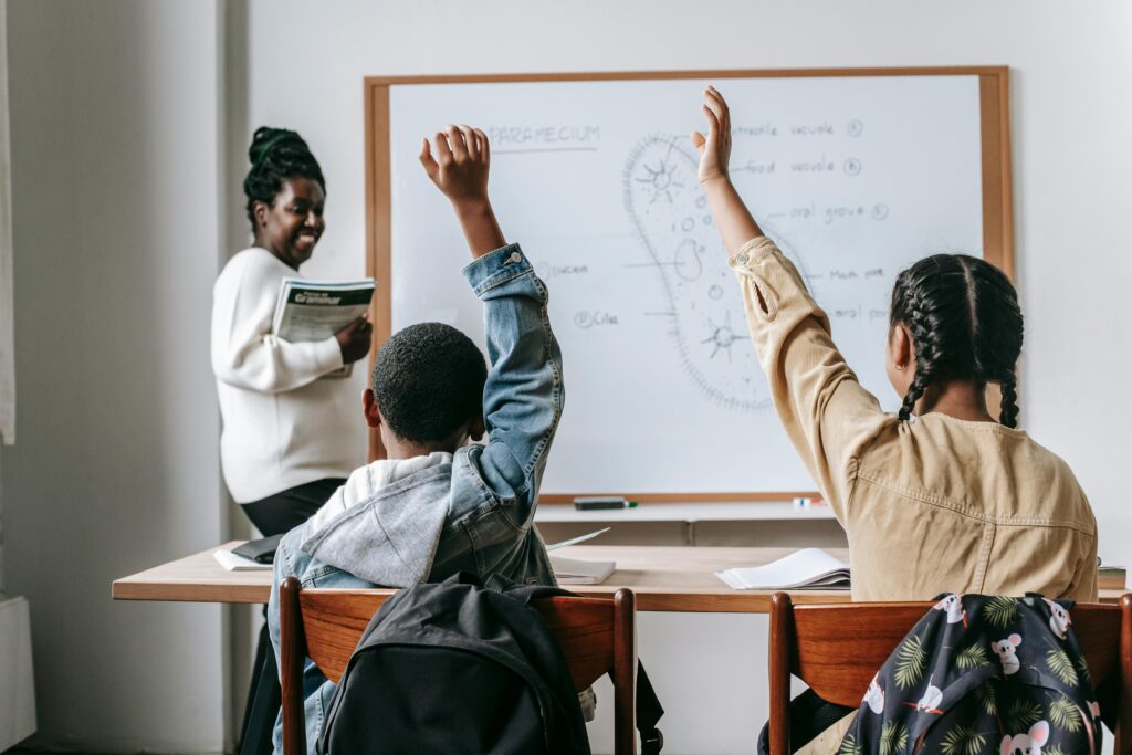 Students raising their hands in class